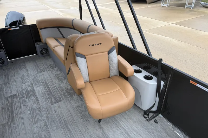 Slide: The Image of 2025 Crest Classic 220 boat interior with tan seating and cup holders. - 5