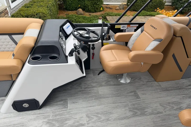 Slide: The Image of 2025 Crest Classic 220 boat interior with tan seating and modern steering console. - 6