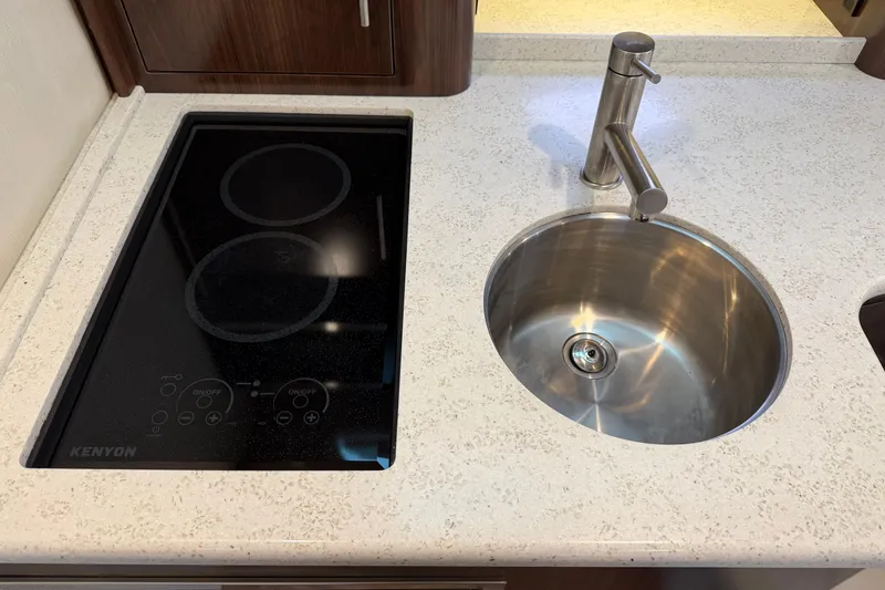 Slide: The Image of Modern kitchen area in a 2017 Regal 35 Sport Coupe with stovetop and round sink. - 13