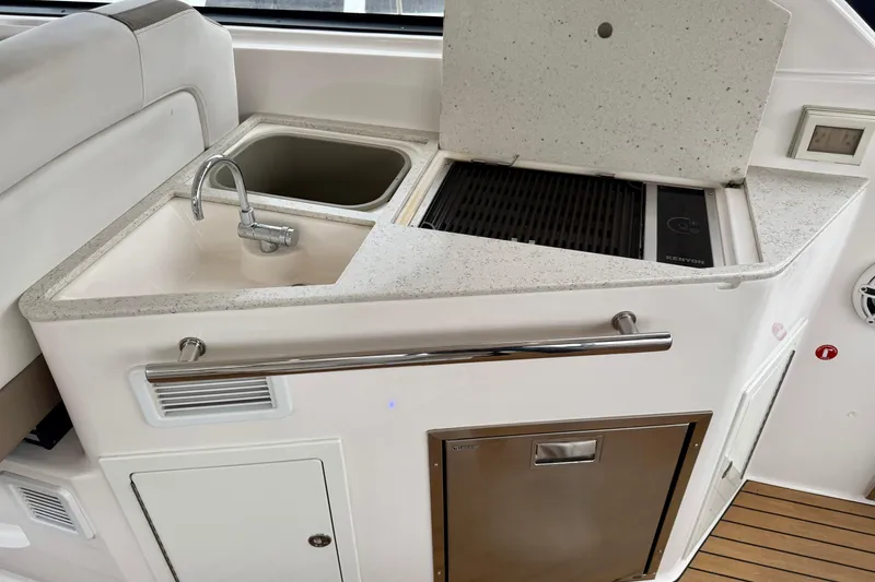 Slide: The Image of 2017 Regal 35 Sport Coupe kitchenette with sink, grill, and storage. - 19
