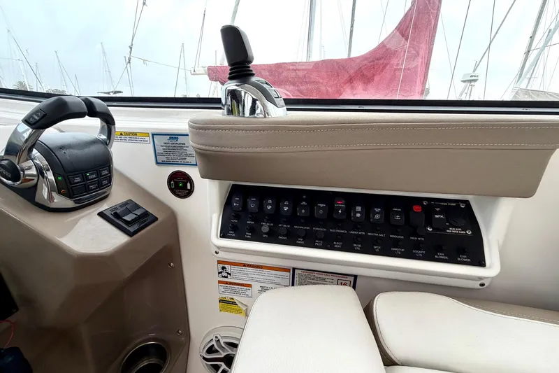 Slide: The Image of Control panel of a 2017 Regal 35 Sport Coupe boat with steering and switches. - 23