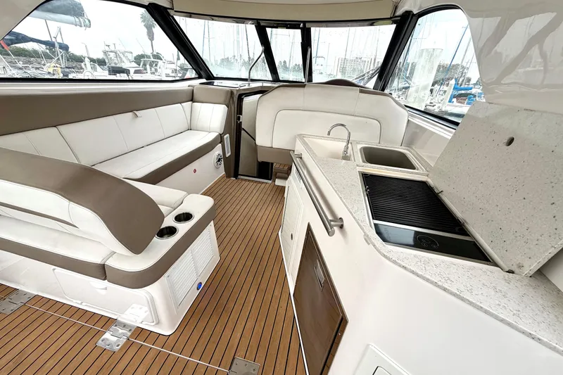 Slide: The Image of 2017 Regal 35 Sport Coupe interior with seating, kitchenette, and wood flooring. - 25
