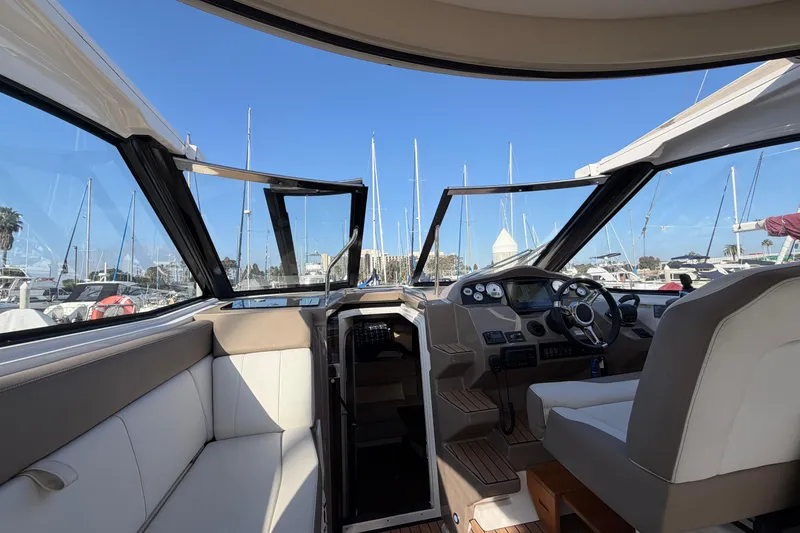 Slide: The Image of Interior view of 2017 Regal 35 Sport Coupe yacht at marina, showcasing helm and seating. - 36