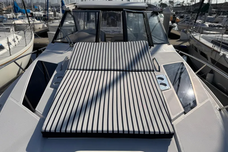 Slide: The Image of 2017 Regal 35 Sport Coupe yacht with striped sun pad, docked at marina. - 40