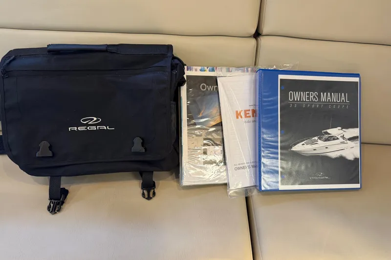 Slide: The Image of Regal 35 Sport Coupe 2017 owner's manual and branded bag on beige surface. - 43