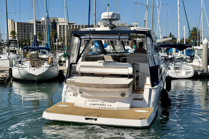 Slide: The Image of 2017 Regal 35 Sport Coupe yacht docked in a marina with sailboats. - 47