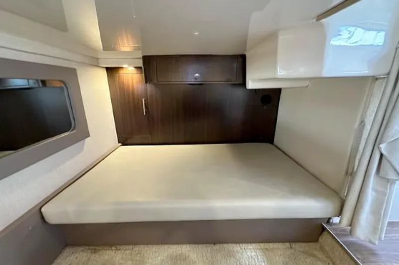 Slide: The Image of Interior cabin of 2017 Regal 35 Sport Coupe with bed and wooden cabinetry. - 9