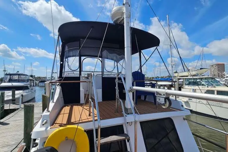 Slide: The Image of 1988 Overseas Monk 42 yacht deck with wooden flooring and metal ladder at marina. - 10