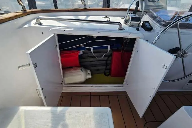 Slide: The Image of Open storage compartment on 1988 Overseas Monk 42 boat with nautical equipment. - 14
