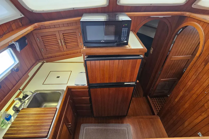 Slide: The Image of Galley of 1988 Overseas Monk 42 yacht with wooden cabinetry, sink, and microwave. - 37