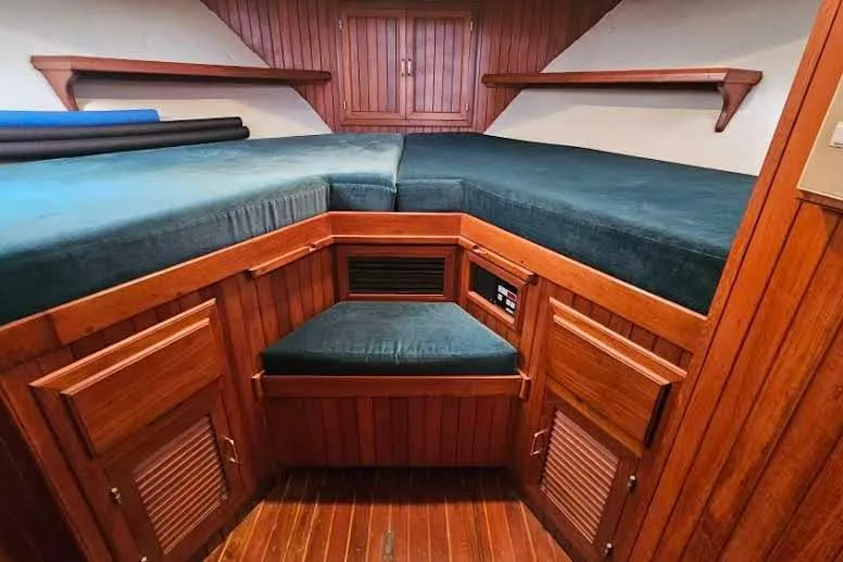 Slide: The Image of 1988 Overseas Monk 42 cabin interior with wooden paneling and blue cushions. - 58