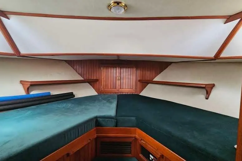Slide: The Image of Interior cabin of 1988 Overseas Monk 42 yacht with green upholstery and wooden accents. - 59