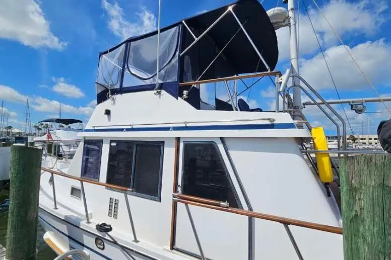 Slide: The Image of 1988 Overseas Monk 42 yacht docked under a clear blue sky. - 6
