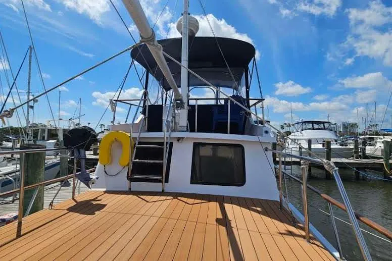 Slide: The Image of 1988 Overseas Monk 42 yacht docked at marina under blue sky. - 7