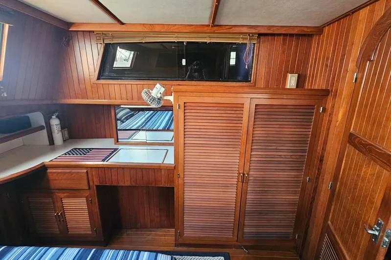 Slide: The Image of Luxurious 1988 Overseas Monk 42 yacht interior with wood paneling and cozy bedroom. - 78