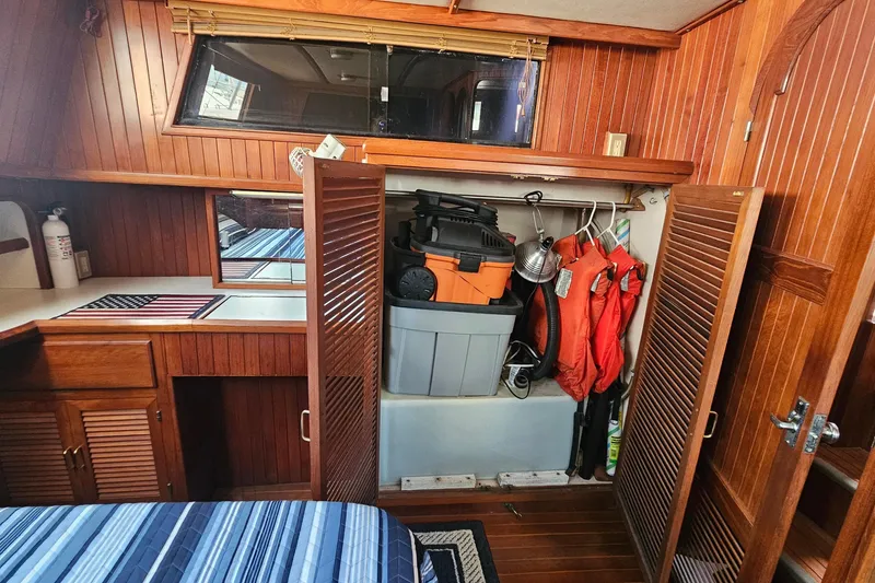 Slide: The Image of Interior of 1988 Overseas Monk 42 yacht with wooden cabinetry and striped bedding. - 79