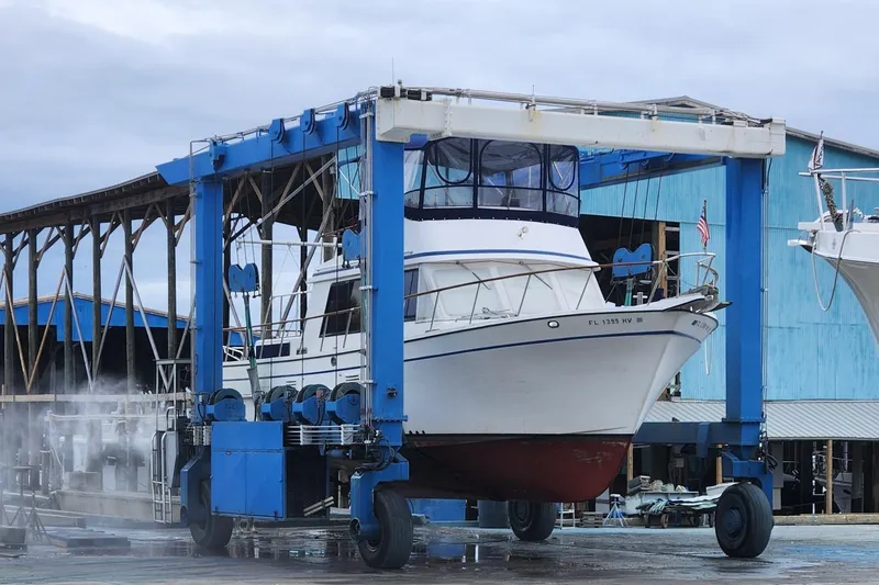 Slide: The Image of 1988 Overseas Monk 42 boat in dry dock, undergoing maintenance at a shipyard. - 102