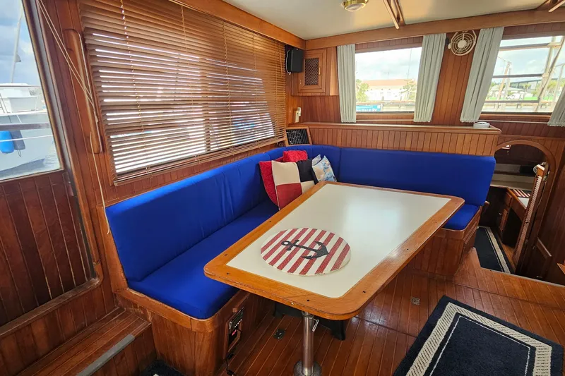 Slide: The Image of Interior of 1988 Overseas Monk 42 yacht with blue seating and wooden accents. - 23