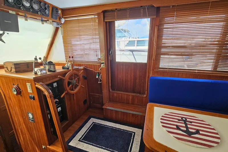 Slide: The Image of Cozy interior of 1988 Overseas Monk 42 yacht with wooden helm and nautical decor. - 25