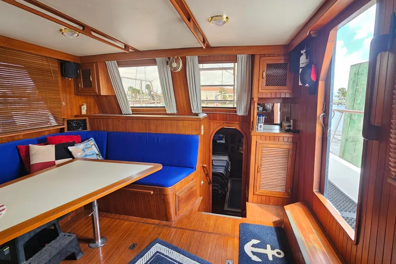 Slide: The Image of Interior of 1988 Overseas Monk 42 yacht with wooden decor and blue seating. - 29