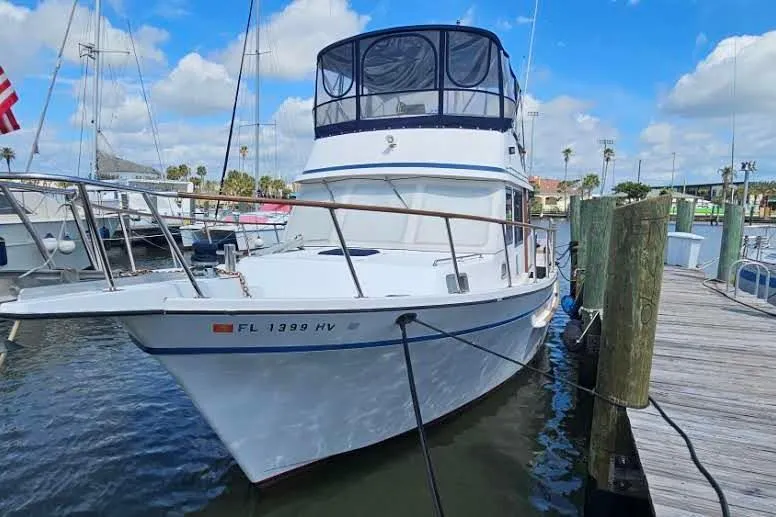 Slide: The Image of 1988 Overseas Monk 42 yacht docked at marina under blue sky. - 3