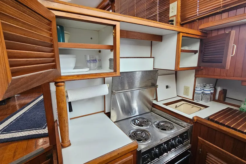 Slide: The Image of Compact kitchen in 1988 Overseas Monk 42 boat with stove, cabinets, and wooden accents. - 36