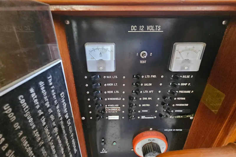 Slide: The Image of Control panel of a 1988 Overseas Monk 42 boat with switches and gauges. - 49