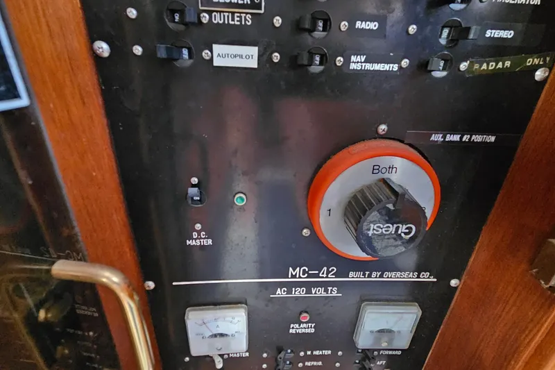 Slide: The Image of Control panel of a 1988 Overseas Monk 42 boat, featuring switches and gauges. - 50