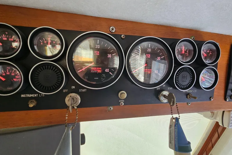 Slide: The Image of Dashboard of a 1988 Overseas Monk 42 boat with various gauges and controls. - 54