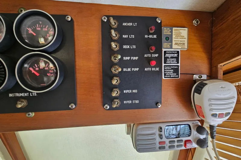 Slide: The Image of Control panel of a 1988 Overseas Monk 42 boat with gauges and switches. - 55