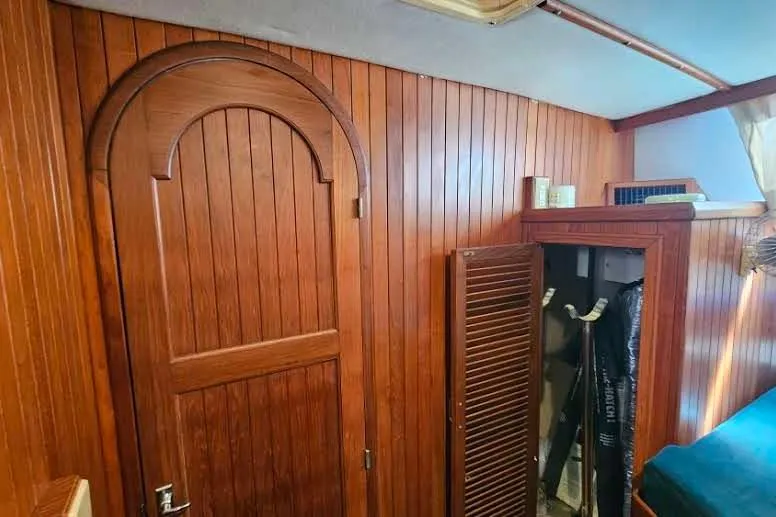 Slide: The Image of Wood-paneled interior of 1988 Overseas Monk 42 boat with arched door and storage. - 61