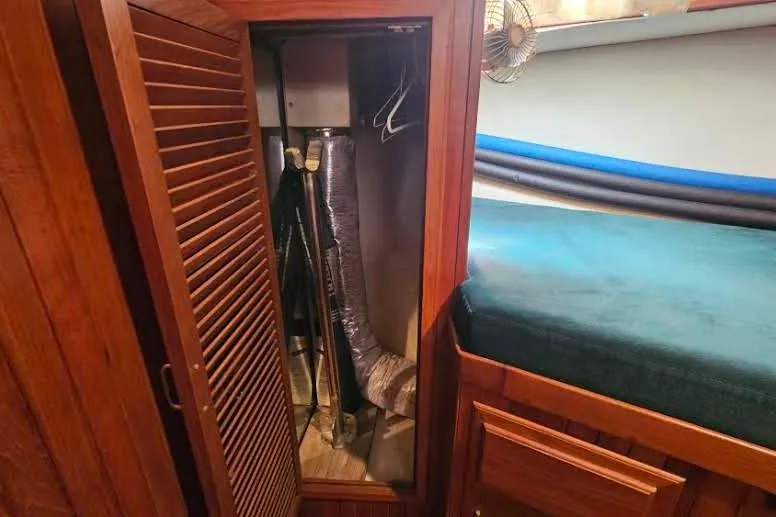 Slide: The Image of Wooden closet interior on 1988 Overseas Monk 42 boat, featuring storage and ventilation. - 62