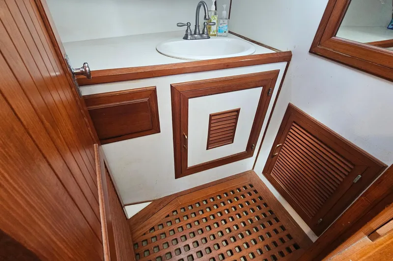 Slide: The Image of Wood-paneled bathroom interior of 1988 Overseas Monk 42 yacht with sink and storage cabinets. - 66