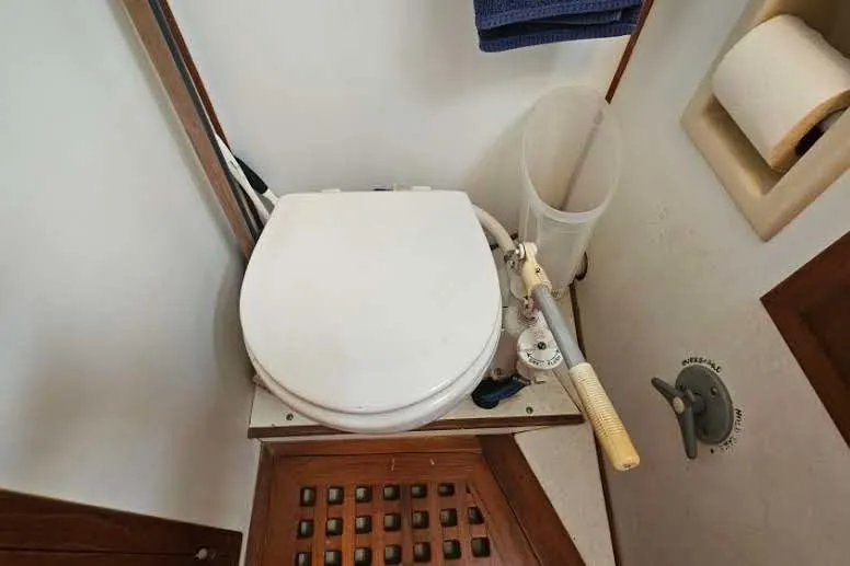 Slide: The Image of Marine toilet in 1988 Overseas Monk 42 boat, featuring manual pump and wooden flooring. - 70