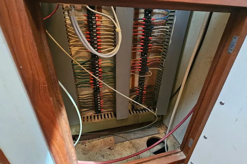 Slide: The Image of Electrical panel inside 1988 Overseas Monk 42 boat, showcasing wiring and connections. - 72