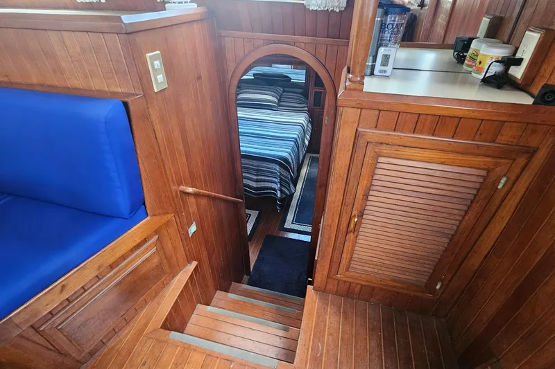 Slide: The Image of Interior of 1988 Overseas Monk 42 yacht with wooden paneling and blue seating. - 73