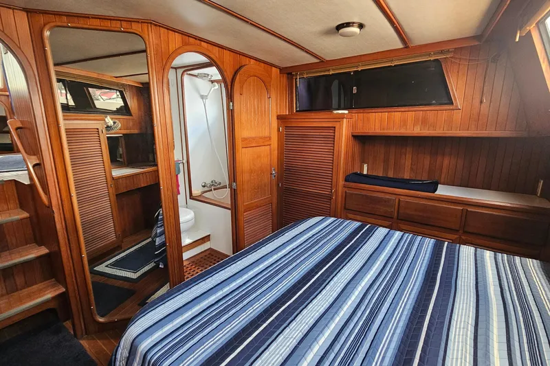Slide: The Image of Luxurious 1988 Overseas Monk 42 yacht interior with wood paneling and cozy bedroom. - 77