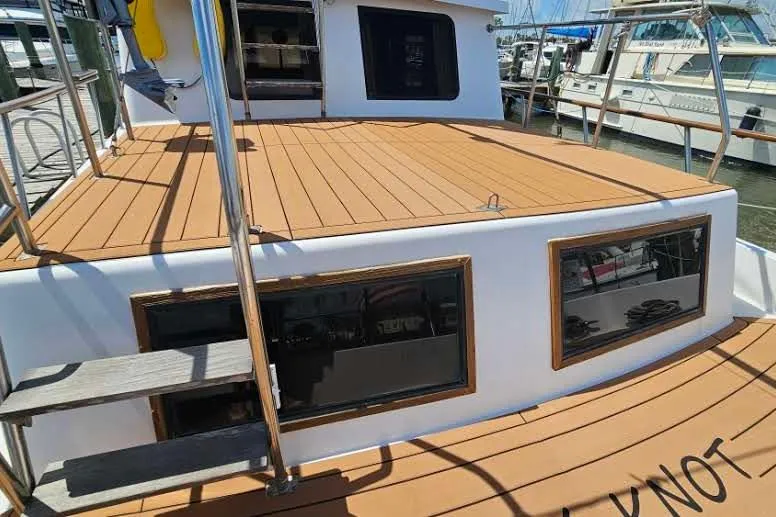 Slide: The Image of 1988 Overseas Monk 42 yacht with wooden deck, docked at marina. - 8
