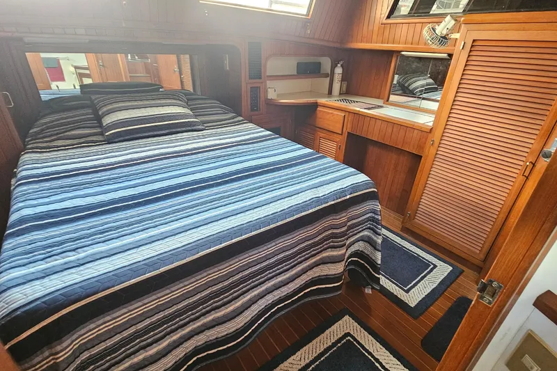 Slide: The Image of Cozy cabin interior of 1988 Overseas Monk 42 yacht with striped bedding and wooden furnishings. - 82