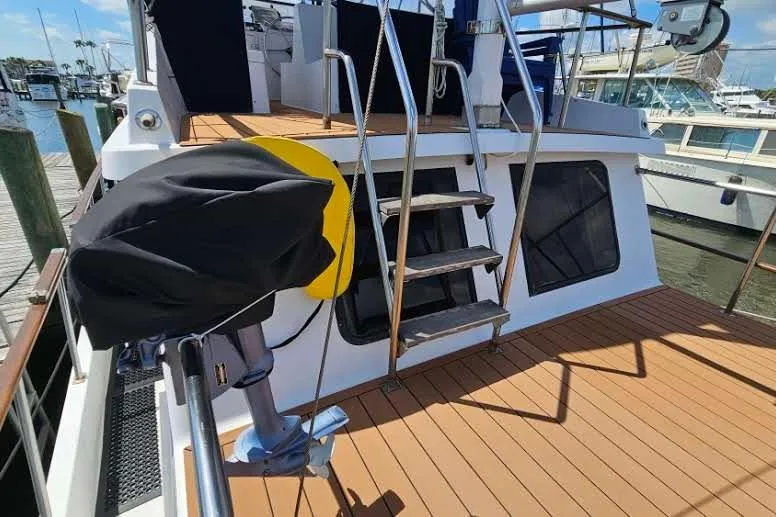 Slide: The Image of 1988 Overseas Monk 42 yacht deck with wooden flooring and metal ladder at marina. - 9