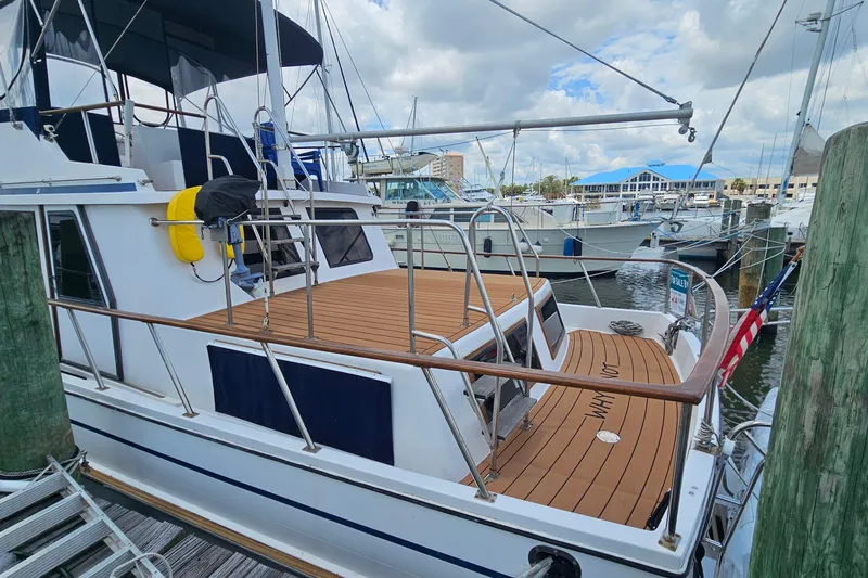 Slide: The Image of 1988 Overseas Monk 42 yacht docked at marina, featuring spacious deck and nautical equipment. - 92