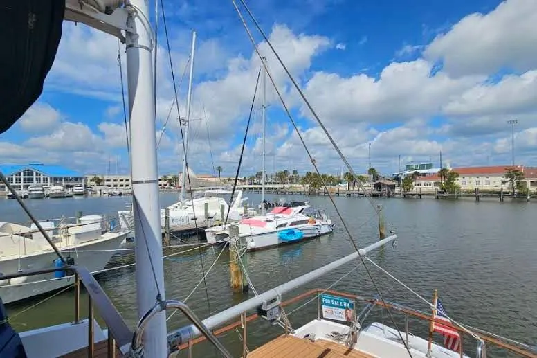 Slide: The Image of Marina view with boats, including a 1988 Overseas Monk 42, under a blue sky. - 97