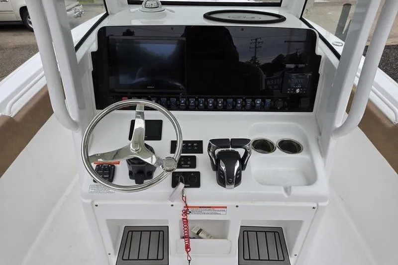 Slide: The Image of Steering console of 2026 Sea Hunt Ultra 265 SE boat with modern controls and displays. - 16