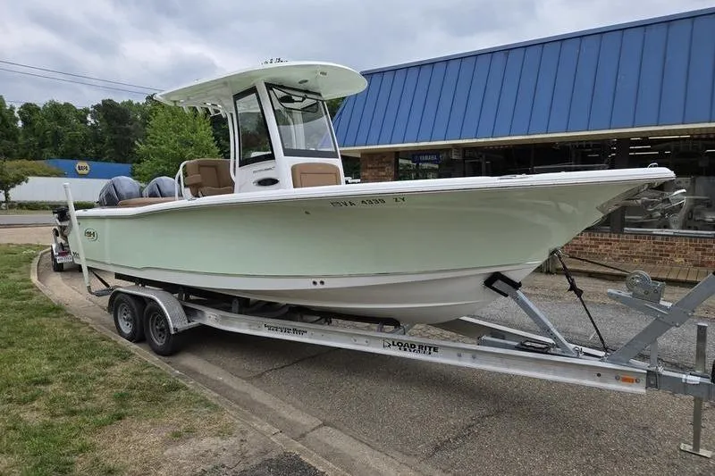 Slide: The Image of 2026 Sea Hunt Ultra 265 SE boat on trailer, parked outside a building. - 4
