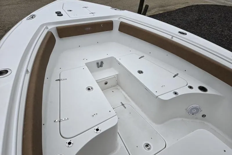 Slide: The Image of 2026 Sea Hunt Ultra 265 SE boat interior with white seating and storage compartments. - 7