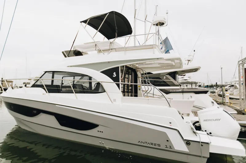 Slide: The Image of 2026 Beneteau Antares 11 Fly yacht docked at marina, side view. - 2