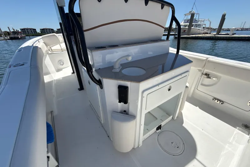 Slide: The Image of 2021 Sea Hunt Ultra 239 SE boat interior with console and seating, docked at marina. - 12