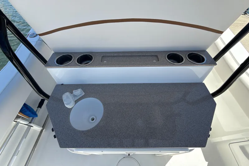 Slide: The Image of 2021 Sea Hunt Ultra 239 SE boat interior with sink and cup holders. - 13