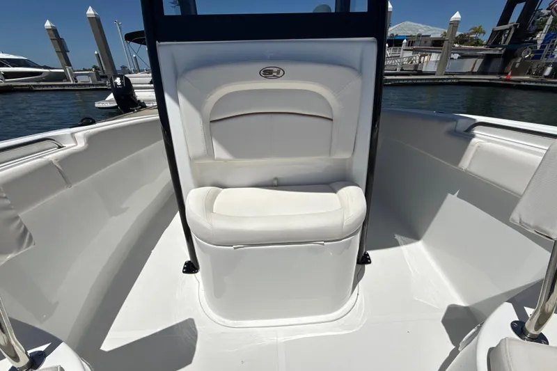Slide: The Image of 2021 Sea Hunt Ultra 239 SE boat interior with white seating at marina. - 16