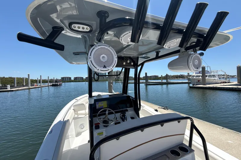 Slide: The Image of 2021 Sea Hunt Ultra 239 SE boat at marina, featuring modern helm and speakers. - 2